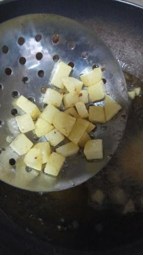 用漏勺舀少许土豆丁晃动，如发出清脆的声音，土豆就已经熟透，可以出锅