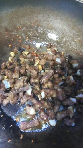 炒香后倒入炸好的排骨翻炒