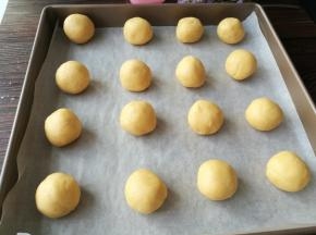 把面团搓成25克一个的小圆球，放入铺了油纸的烤盘。