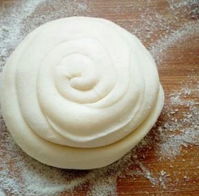 从一头边抻长边卷起来，最后尾部放在下边压好