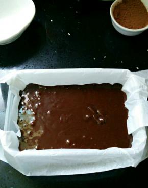 搅拌均匀后将巧克力倒进垫了油纸的容器里