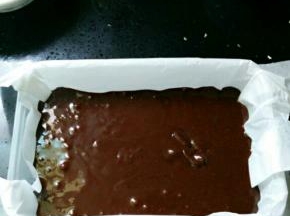 搅拌均匀后将巧克力倒进垫了油纸的容器里