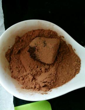 用筷子捡起一块放进可可粉里，均匀的裹上一层可可粉