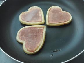 表面有小气泡开始凝固，提起两边倒翻过来，小爱心饼自然脱落，小火煎一分钟即可，小朋友自己迫不及待拿走一个开吃啦