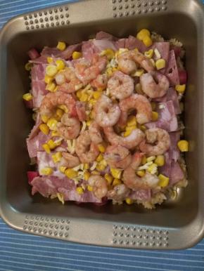 底下铺米饭，撒一层奶酪，铺西红柿，培根，再撒一层奶酪，上面铺玉米，虾仁，最后再铺一层奶酪
