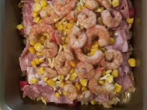 底下铺米饭，撒一层奶酪，铺西红柿，培根，再撒一层奶酪，上面铺玉米，虾仁，最后再铺一层奶酪
