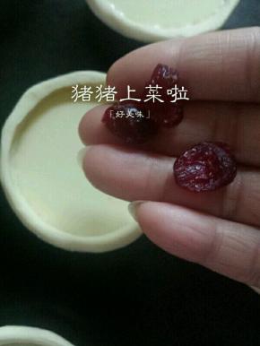 每个蛋挞里放上几个蔓越莓干，烤箱提前预热220度，预热好了将烤盘放进烤箱中层220度上下火20分钟，注意表皮不要烤焦了