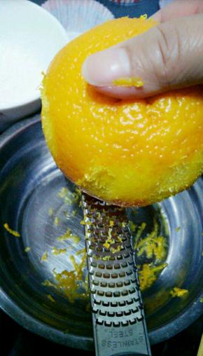 洗干净的橙子用纸巾擦干，然后用削皮屑的工具将橙皮刮下来，要外面一层，白色部分就不要了，直接刮在放油的盘子里