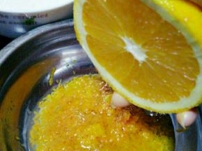 然后橙子切一半，挤出50克橙汁放皮屑一块儿备用