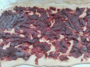 将温热的糯米团放在黄豆粉上，擀开成大长方形，抹上豆沙