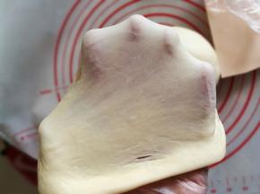 面团揉至光滑后，加入切块黄油，继续和面，揉至能拉出大片面膜，即扩展阶段。