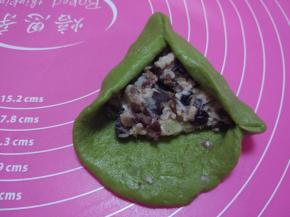 取一个面团擀成圆饼，轻轻排气，不需要排的太干净，包入夹馅，取两个边对在一起捏紧，和包糖包一样。