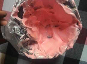 裱花袋剪小口放入樱花嘴，然后将粉色蛋白霜涂抹在裱花袋边缘