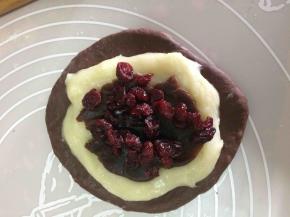 15分钟后，把静置好的面团擀开，铺上一层麻薯，豆沙，蔓越莓