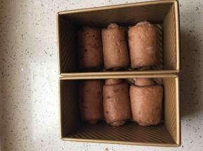 面团排气，擀成椭圆形，卷起，放入吐司盒排好