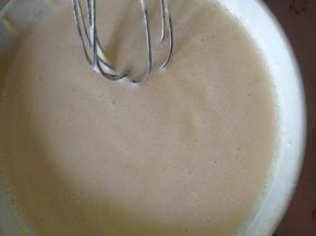 其余牛奶加热成温热牛奶。分两次加进蛋黄糊里，搅拌均匀。