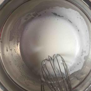 3:制作蛋黄糊。我们先将牛奶、玉米油倒入一个干净的盆中，用手动打蛋器混合均匀（看不见油）