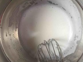 3:制作蛋黄糊。我们先将牛奶、玉米油倒入一个干净的盆中，用手动打蛋器混合均匀（看不见油）