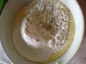 提前把黄油隔水融化，冷却至温热，然后加到蛋黄糊里。搅拌均匀后筛进低粉。