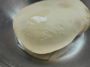 将面团揉成三光，即:盆光，手光，面光，倒入6克花生油，充分揉进去