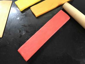 用擀面杖将面团擀成大小、厚度一样的面片。