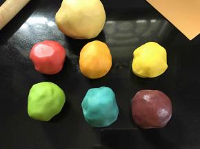 将揉好的面团分成三份，取其中的一份用保鲜袋装起来，放到冰箱冷藏，剩下的两份，每份再平均分成三份。分别加入色素揉和均匀，用保鲜袋包好。