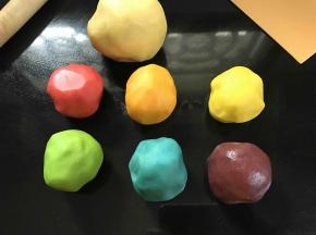 将揉好的面团分成三份，取其中的一份用保鲜袋装起来，放到冰箱冷藏，剩下的两份，每份再平均分成三份。分别加入色素揉和均匀，用保鲜袋包好。