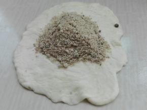 取一个剂子，两头朝中间捏紧，擀成中间厚，周边薄，包红糖馅