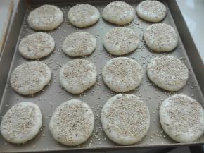 封口朝下，按压成圆饼，表面刷点糖水，撒芝麻，按压一下