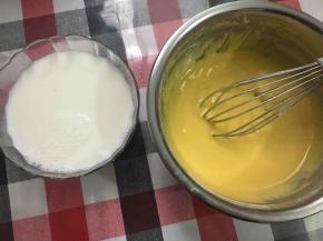 将240g纯牛奶和130g热水混合，成温热牛奶液，分2次加入蛋黄糊里