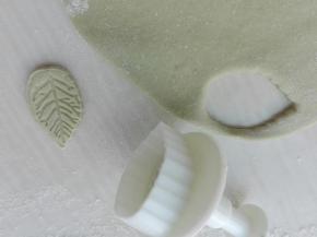 开始制作表面装饰品，将调好颜色的面团擀成薄片，用模具按压出喜欢的图案