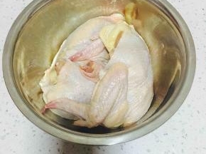 洗干净控好水的鸡一分为二，用牙签在鸡身上扎些小孔。