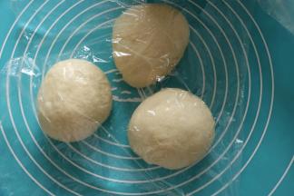 取出面团，挤压排气后，平均分成三等份，保鲜膜覆盖，滚圆松弛15分钟。