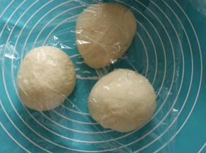 取出面团，挤压排气后，平均分成三等份，保鲜膜覆盖，滚圆松弛15分钟。