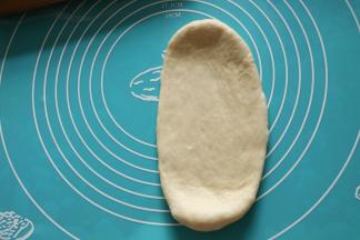 第一次擀卷：取一面团擀成椭圆形。