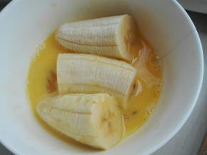 将香蕉段放入打撒的蛋液中，裹上一层蛋液