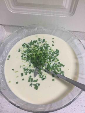 少量多次加水入面粉中，把面糊搅拌均匀，无明显颗粒状，面糊的稀稠决定饼的厚薄，然后把香葱切碎放入面糊中拌匀