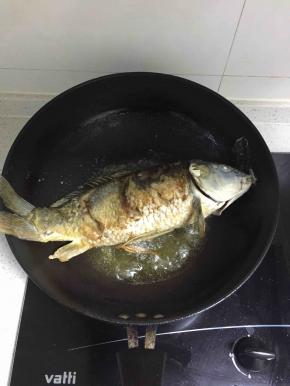 然后轻轻放入油锅把两面煎黄。煎鱼有个诀窍就是热锅冷油放入鱼，还有就是一面煎好再翻另一面，这样能保持鱼皮的完整。