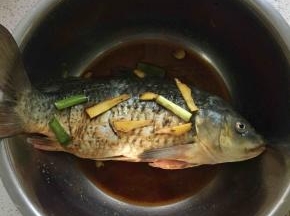 先把鱼清洗干净，鱼背上打花刀，然后加入适量料酒、生抽、盐、十三香、葱姜腌制半小时至一个小时。