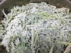 锅内加水，笼屉上铺好纱布，把拌好的茼蒿放入蒸锅内