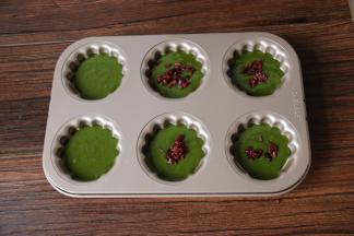 10裱花袋前端剪口，把蛋糊挤入。九分满即可表面撒少许切碎的蔓越莓干颗粒。