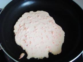 锅里倒入少许底油，转一下锅，倒入面糊。