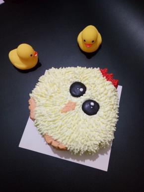 调一点红色奶油，抹鸡冠，鸡脚和嘴巴用红色加黄色调出来，眼睛用黑巧克力融化挤得，上面用牙签点淡奶油