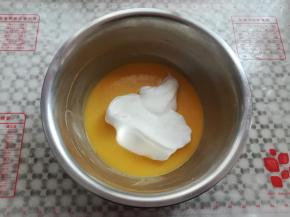 取三分之一蛋白霜放入蛋黄糊，2-8点钟方向手法翻拌均匀