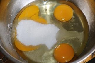 2干净无水无油的盆里，打入鸡蛋，加入细砂糖。