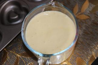 6把面糊装入裱花袋或者量杯，方便倒入模具，当然也可以直接倒入模具。装入模具八分满即可。