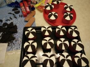 隔冰水打发淡奶油至硬性（加入全部细砂糖）。杯子蛋糕上铺平奶油，放上奥利奥切出的眉毛和翅膀