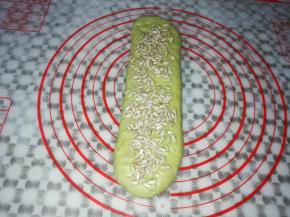 取一个面团擀成细长条，撒上适量的葵花籽，从下往上再次卷起来
