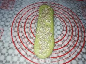 取一个面团擀成细长条，撒上适量的葵花籽，从下往上再次卷起来