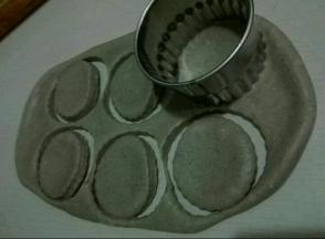 醒发好的面团，擀成大片，找出同杯子蛋糕模具大小的圆形，扣压六个圆形出来